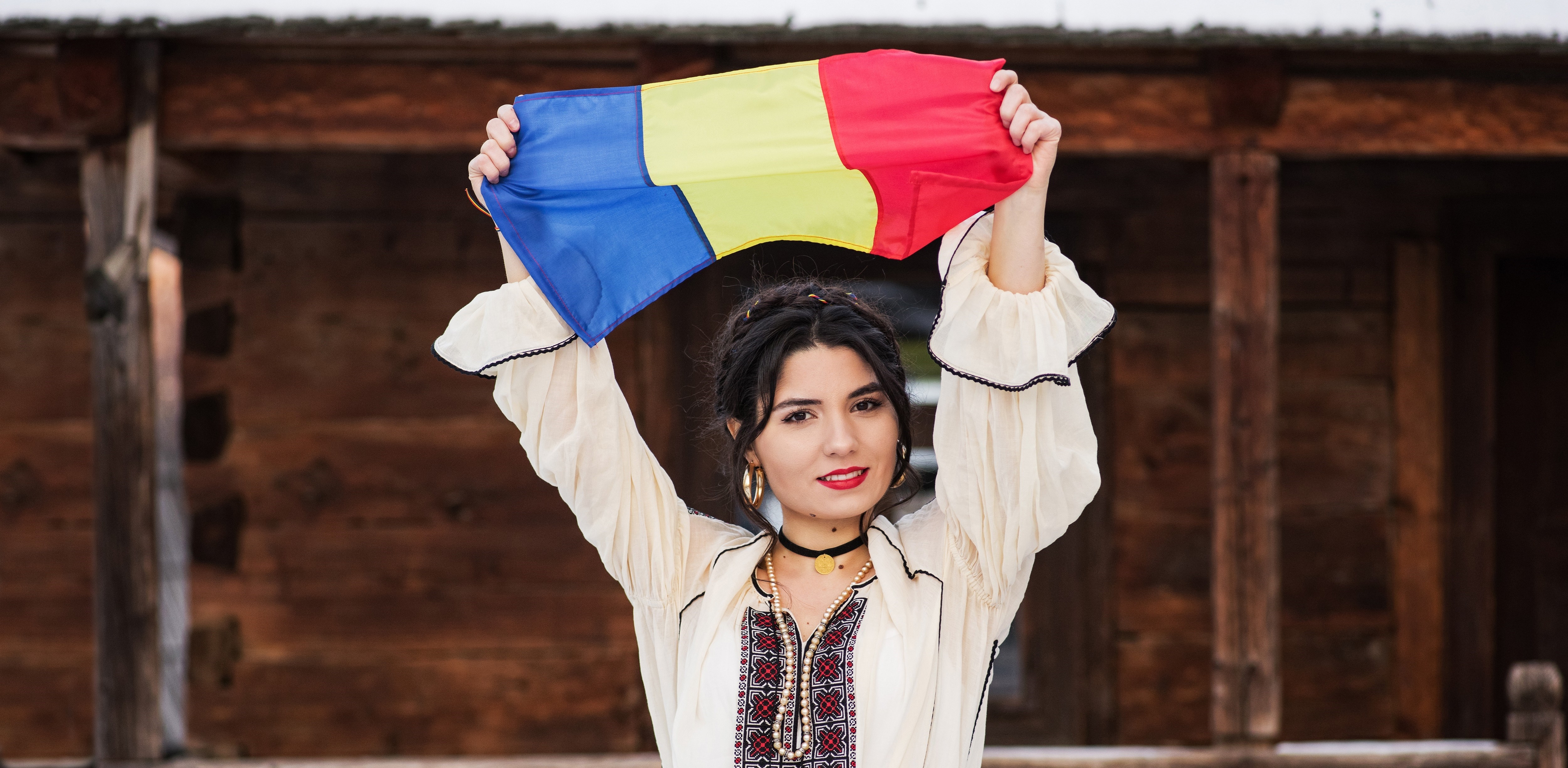 Portret of a beautiful young woman posing in romanian traditional costume