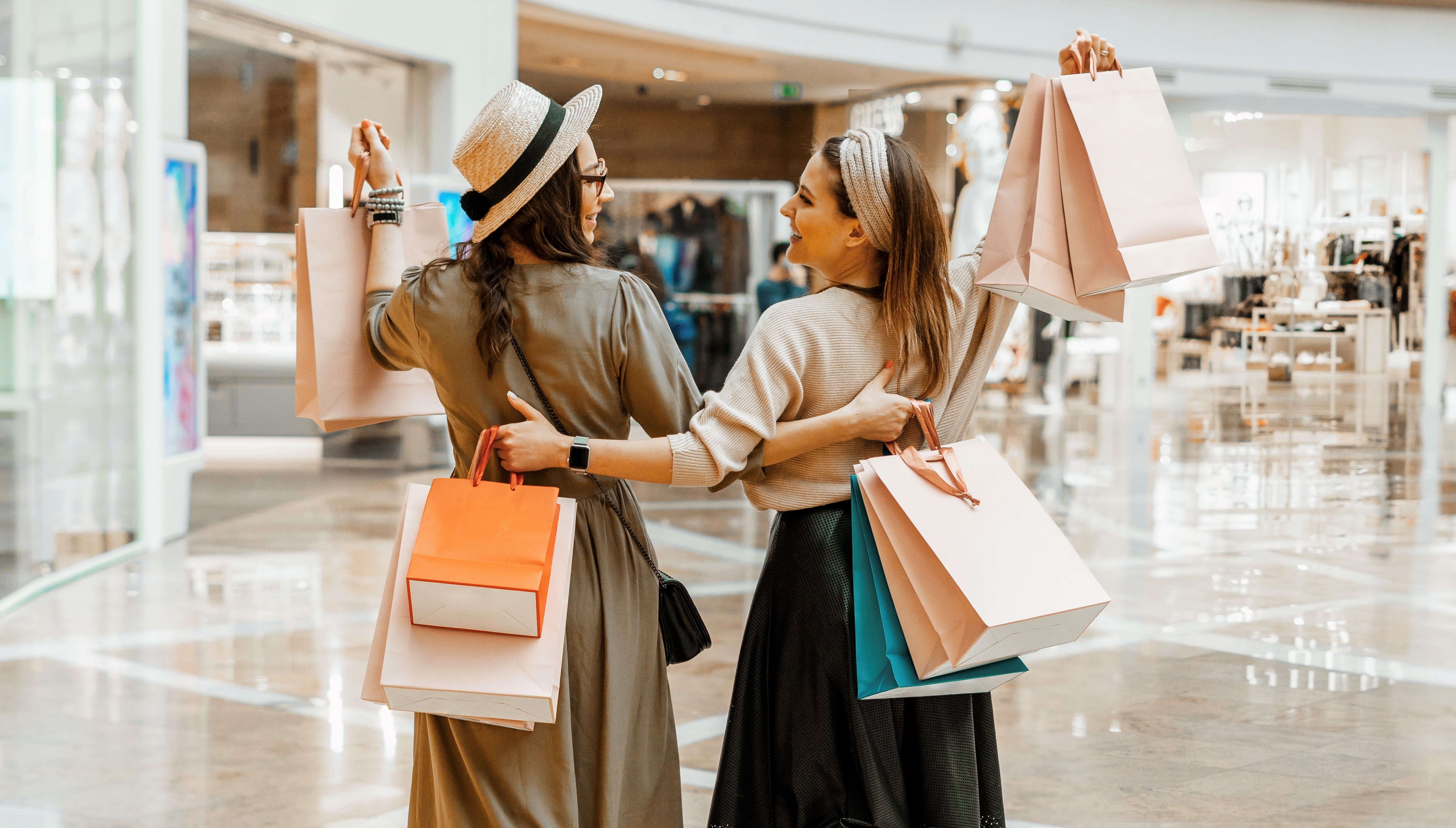Two beautiful girls with paper bags at the mall