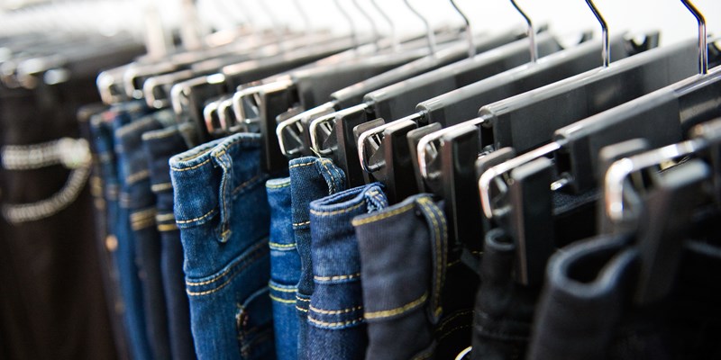 Row of hanged blue and black jeans in a shop