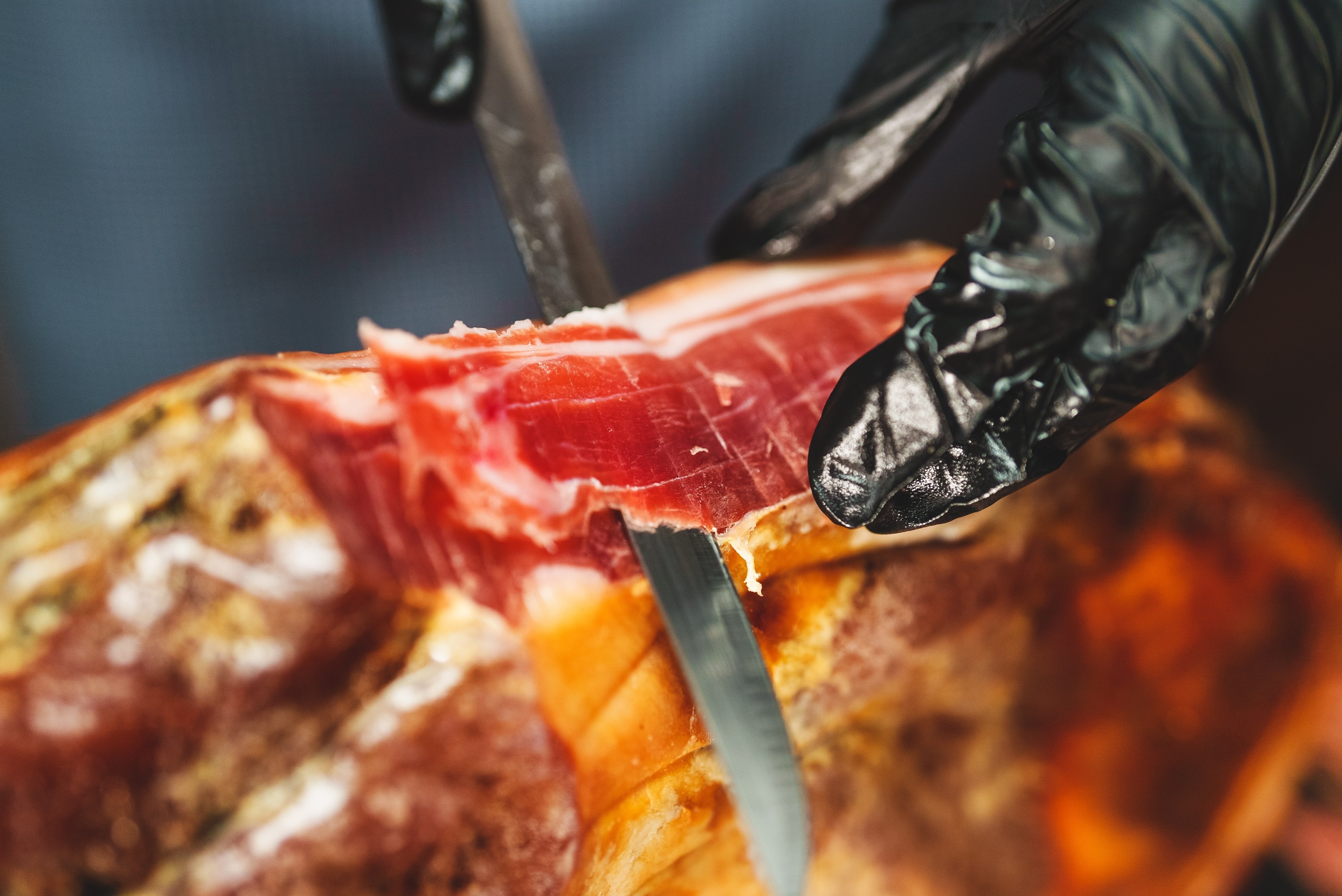 Chef cutting dry-cured spanish ham Jamon.