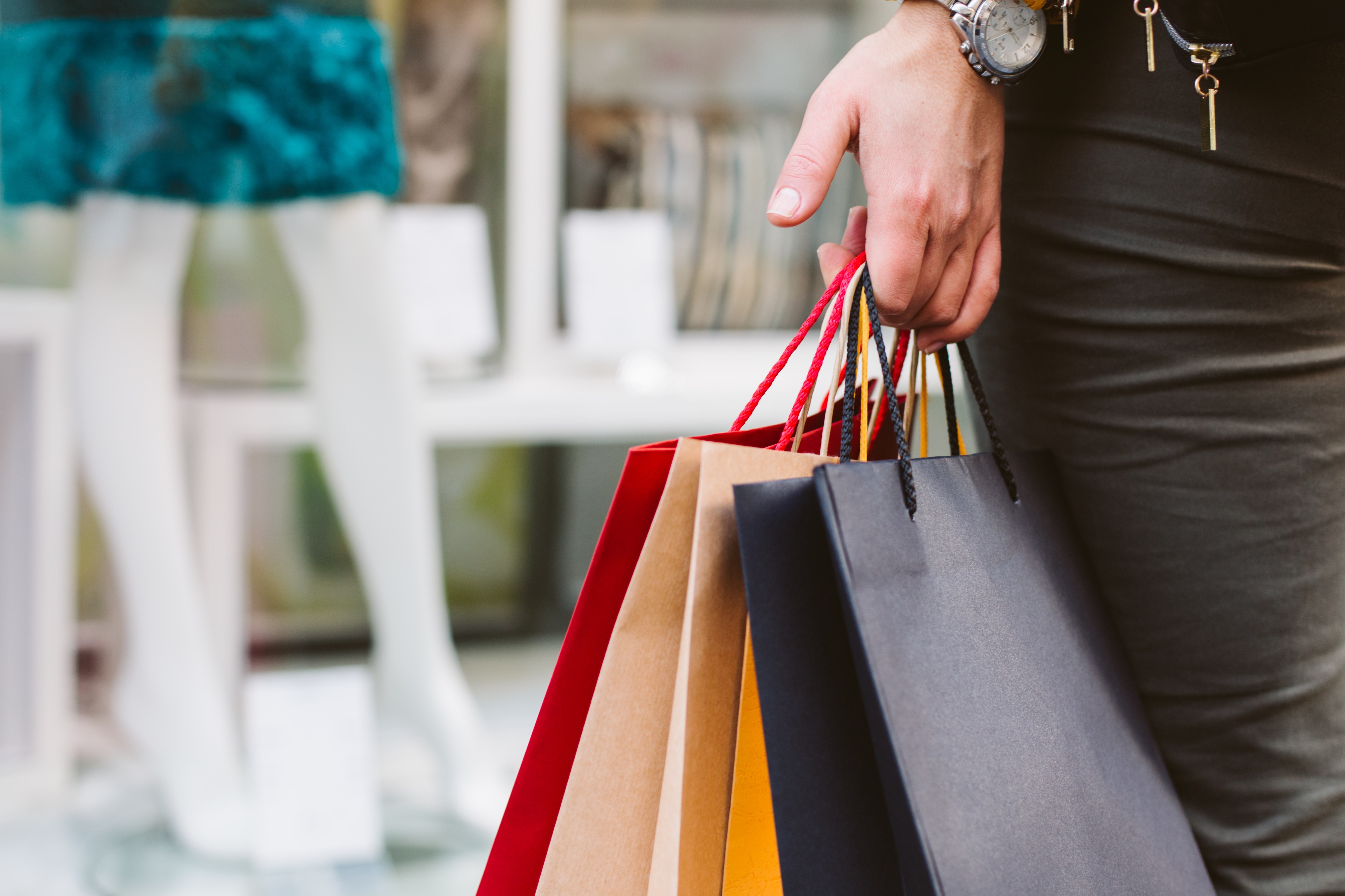 Closeup of woman holding shopping bags in front of a shop window